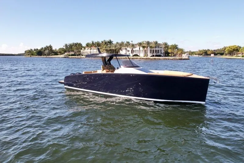 Slide: The Image of 2023 Tesoro T38 luxury yacht cruising on a sunny day near a waterfront mansion. - 4