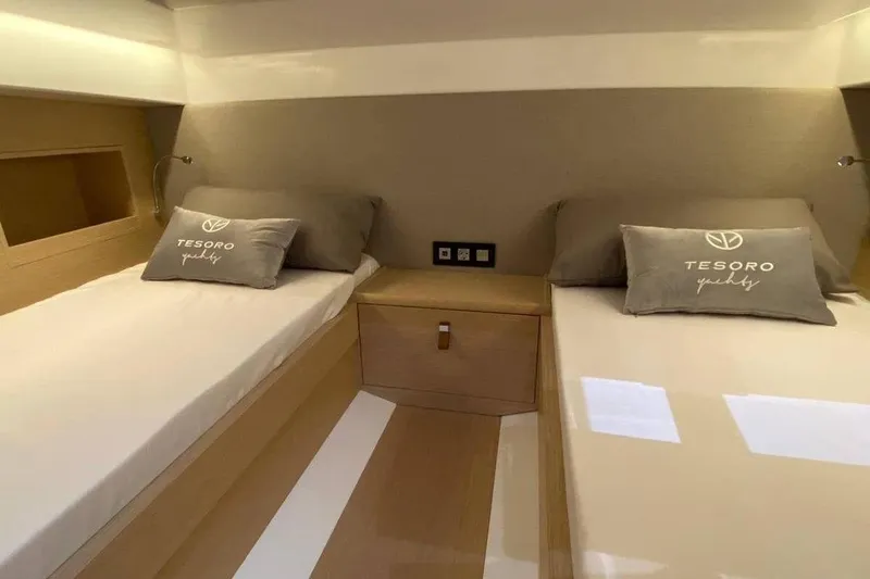 Slide: The Image of 2023 Tesoro T38 yacht cabin with twin beds and branded pillows. - 48