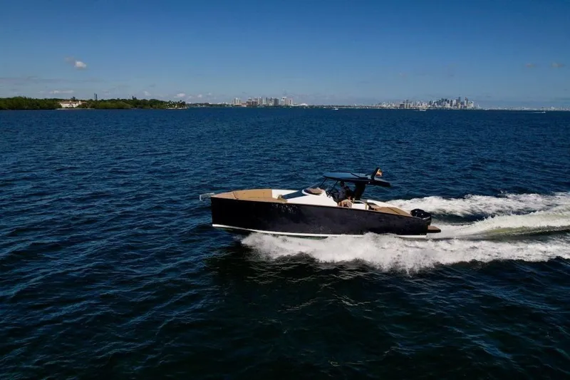 Slide: The Image of 2023 Tesoro T38 yacht cruising on open water with city skyline in background. - 8