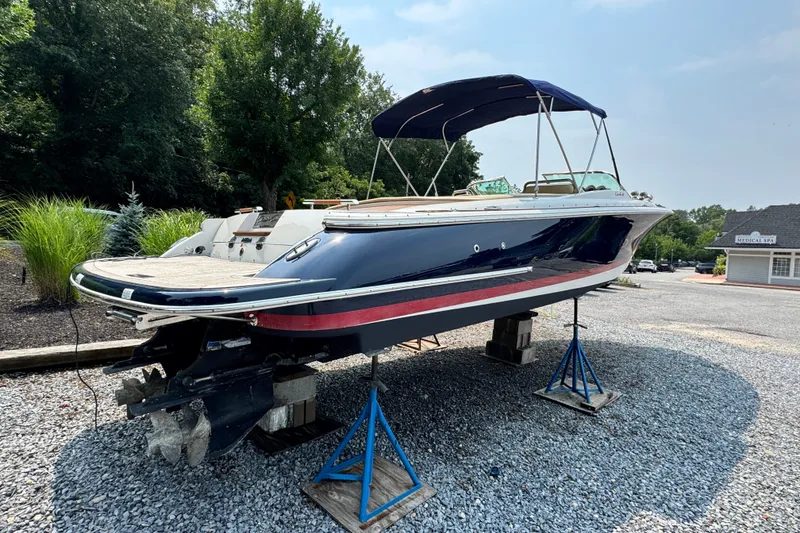 Slide: The Image of 2013 Chris-Craft Launch 28 boat on stands, blue hull, outdoor setting. - 5