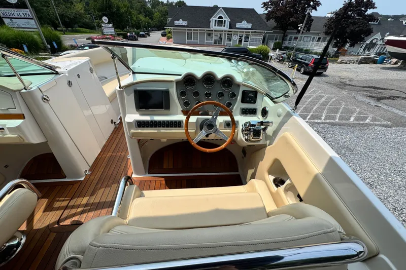Slide: The Image of 2013 Chris-Craft Launch 28 boat interior with wooden dashboard and steering wheel. - 11