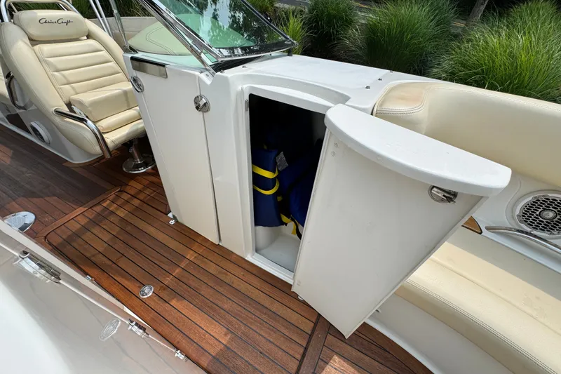 Slide: The Image of 2013 Chris-Craft Launch 28 interior with open storage, beige seating, and wooden flooring. - 21