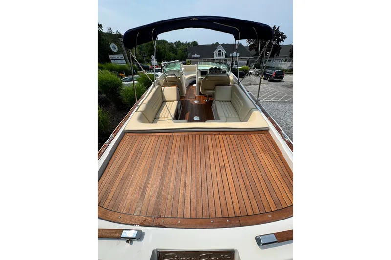 Slide: The Image of 2013 Chris-Craft Launch 28 boat with teak deck and beige seating, docked outdoors. - 8