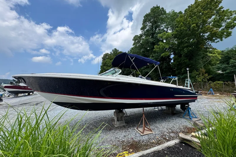 Slide: The Image of 2013 Chris-Craft Launch 28 boat on dry dock, surrounded by greenery and blue sky. - 4
