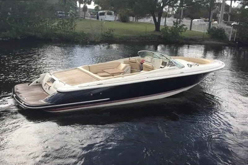 Slide: The Image of 2013 Chris-Craft Launch 28 boat on calm water, featuring elegant design and spacious seating. - 3