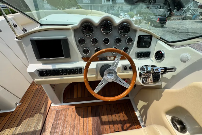 Slide: The Image of 2013 Chris-Craft Launch 28 dashboard with wooden steering wheel and modern controls. - 12