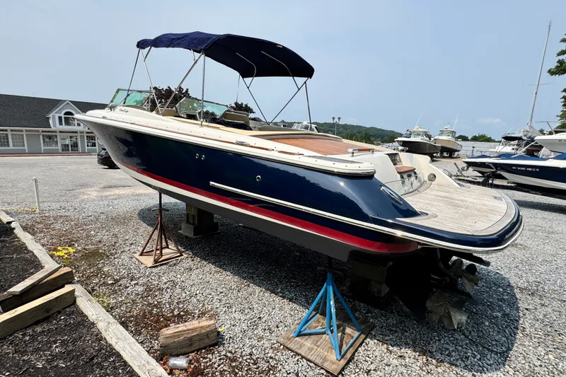 Slide: The Image of 2013 Chris-Craft Launch 28 boat on stands, blue hull, outdoor display. - 6