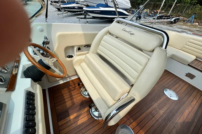 Slide: The Image of 2013 Chris-Craft Launch 28 boat interior with leather seating and wooden steering wheel. - 18
