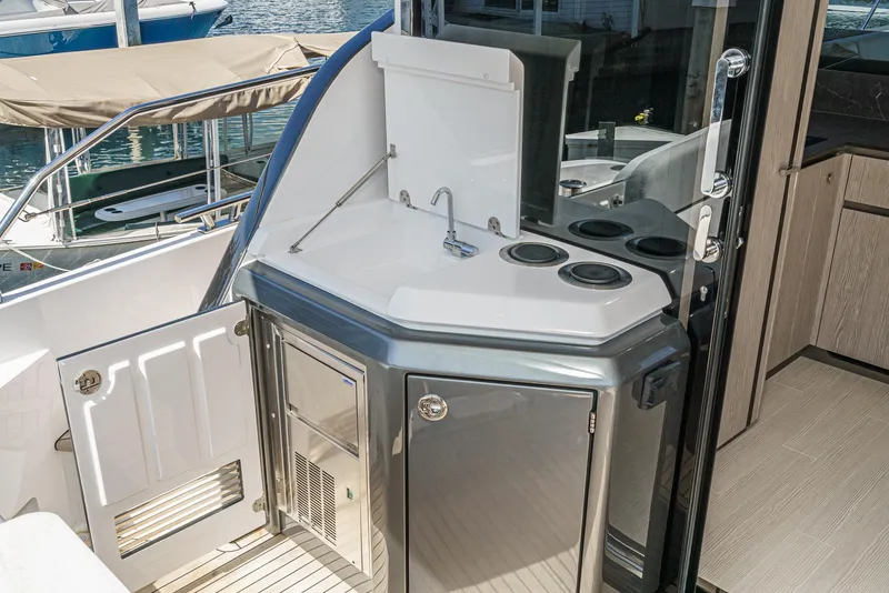 Slide: The Image of 2024 Azimut Fly 53 yacht kitchenette with sink and stove, docked at marina. - 24