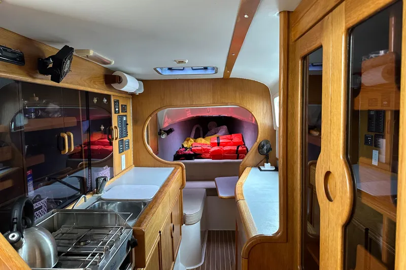 Slide: The Image of Interior of 2008 Seawind 1000 XL catamaran with wood finish and compact kitchen. - 15