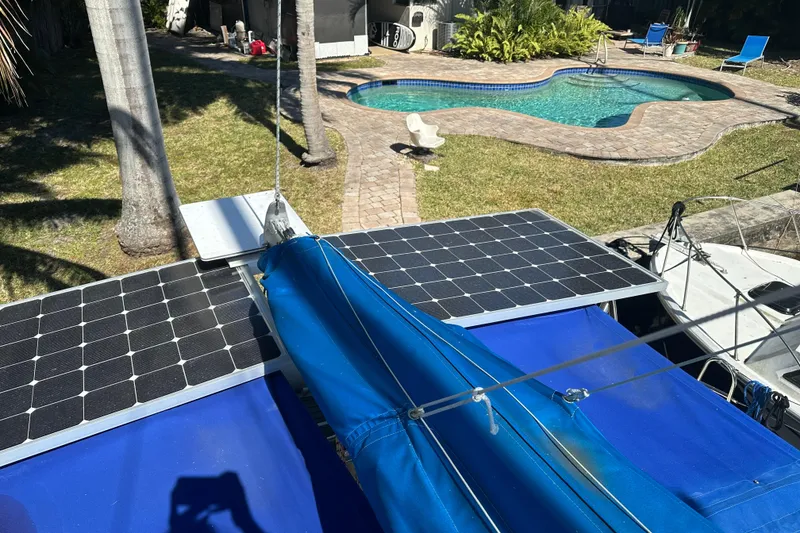 Slide: The Image of Seawind 1000 XL 2008 catamaran with solar panels, docked near a poolside patio. - 34