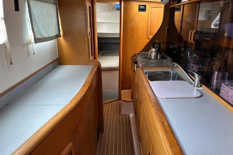 Slide: The Image of Interior of 2008 Seawind 1000 XL catamaran with wooden cabinetry and compact kitchen area. - 4