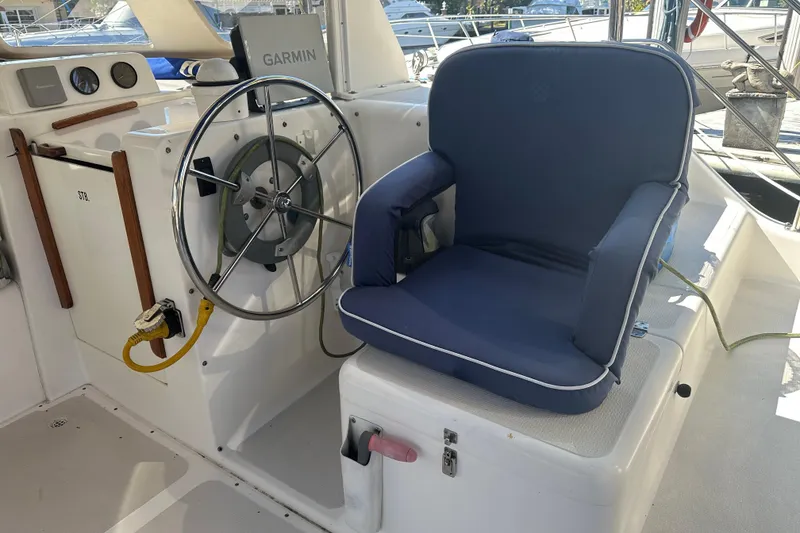 Slide: The Image of Steering area of 2008 Seawind 1000 XL catamaran with blue cushioned seat and Garmin equipment. - 47