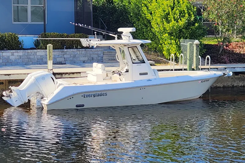 The Image of 2017 Everglades 255 Center Console boat docked by a waterfront home. - 0