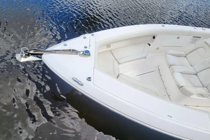 Slide: The Image of 2017 Everglades 255 Center Console boat with white seating, anchored on calm water. - 14