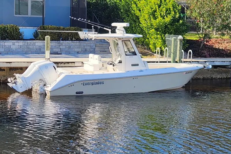 Slide: The Image of 2017 Everglades 255 Center Console boat docked on calm water. - 2