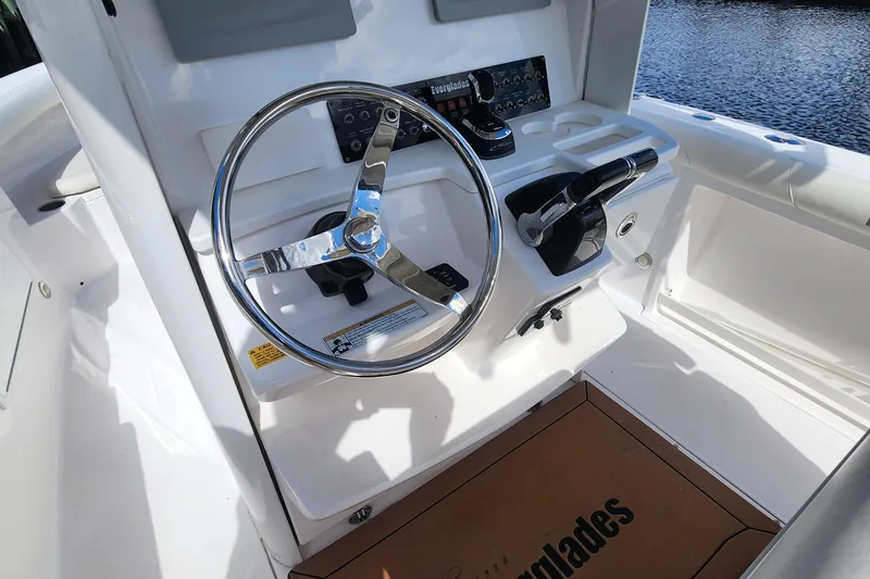 Slide: The Image of Steering console of 2017 Everglades 255 Center Console boat, featuring chrome wheel and controls. - 24