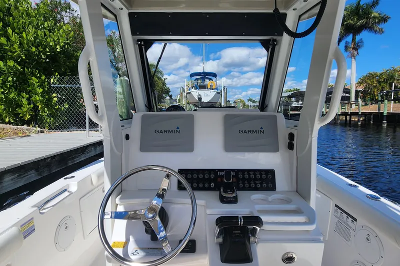 Slide: The Image of 2017 Everglades 255 Center Console boat helm with Garmin navigation system, docked by a canal. - 48