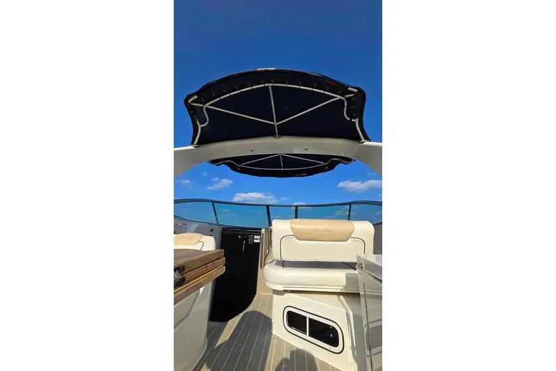 Slide: The Image of 2009 Sea Ray 270 Sundancer interior with canopy, showcasing seating and clear blue sky. - 10