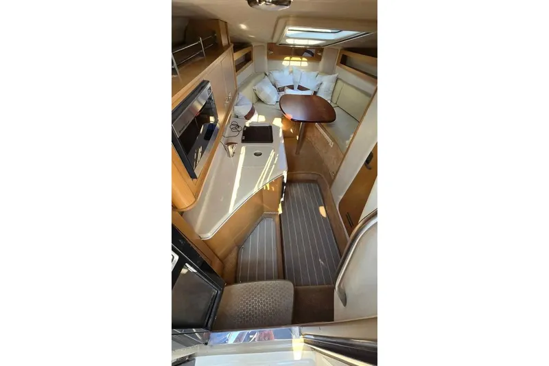 Slide: The Image of 2009 Sea Ray 270 Sundancer cabin interior with kitchenette and seating area. - 16