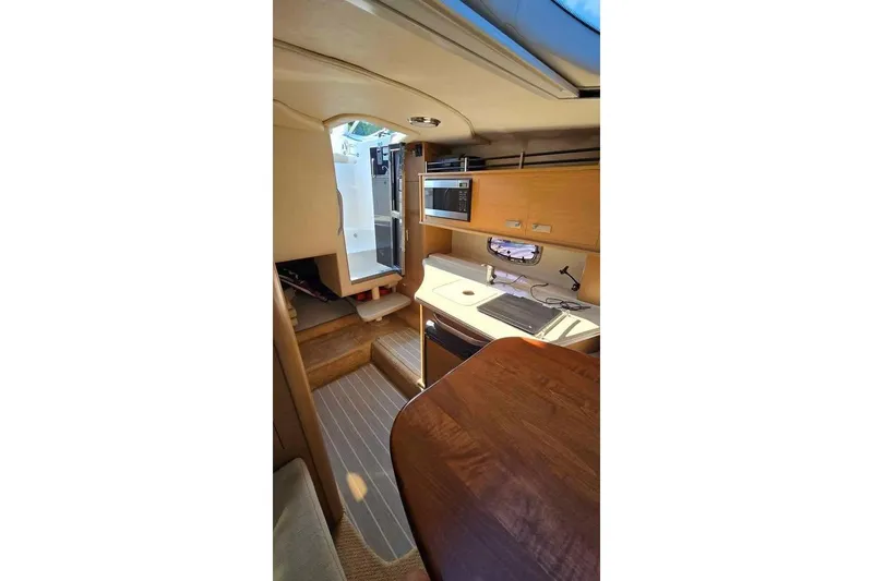 Slide: The Image of Interior of 2009 Sea Ray 270 Sundancer, featuring kitchenette and seating area. - 17