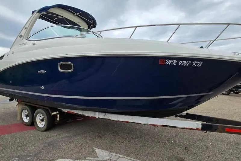 Slide: The Image of 2009 Sea Ray 270 Sundancer boat on trailer, blue and white exterior. - 19