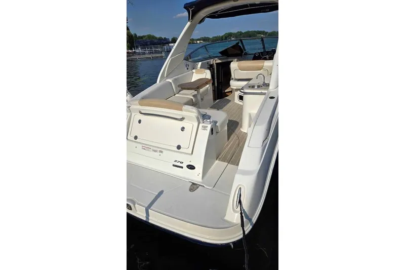 Slide: The Image of 2009 Sea Ray 270 Sundancer boat docked, showcasing spacious deck and seating area. - 7