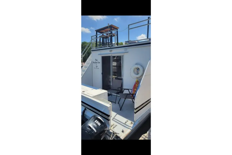 Slide: The Image of 2000 Catamaran Cruisers 48 houseboat with outdoor seating and upper deck, named "The Anchor Inn." - 11