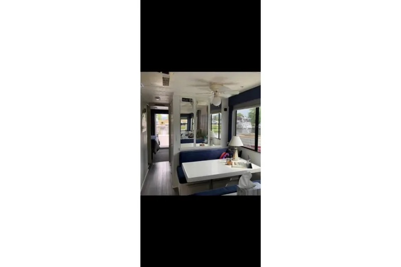 Slide: The Image of Interior of 2000 Catamaran Cruisers 48, featuring dining area with blue seating. - 12