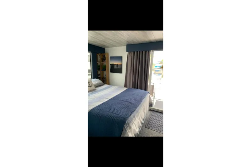 Slide: The Image of Cozy bedroom interior of 2000 Catamaran Cruisers 48 with nautical decor and large bed. - 3