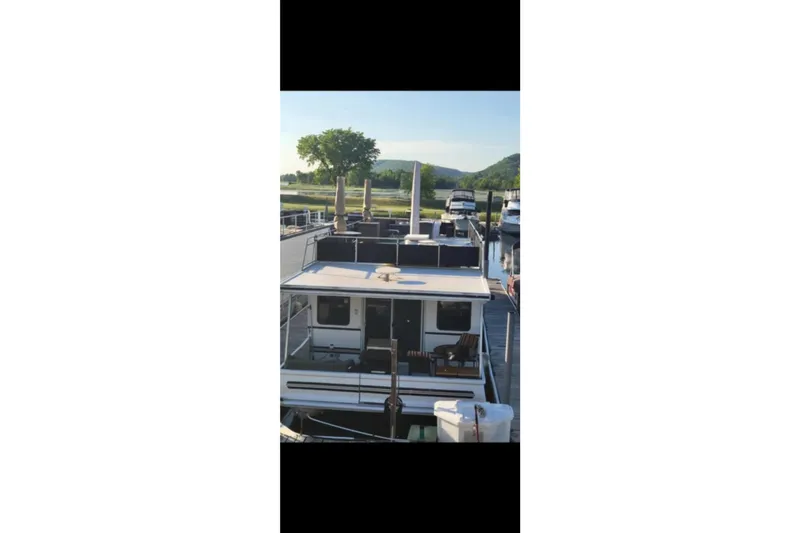 Slide: The Image of Catamaran Cruisers 48 houseboat, 2000 model, docked with scenic background. - 4