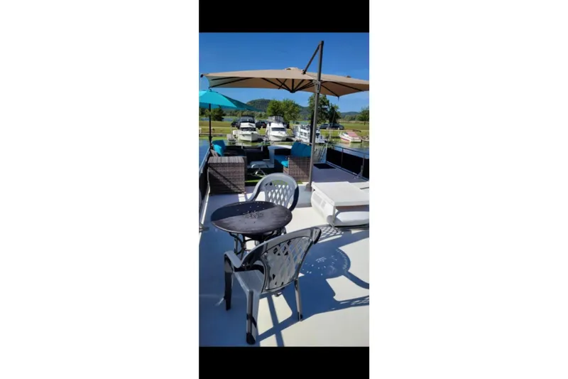 Slide: The Image of Outdoor seating on 2000 Catamaran Cruisers 48, featuring umbrellas and scenic marina view. - 6