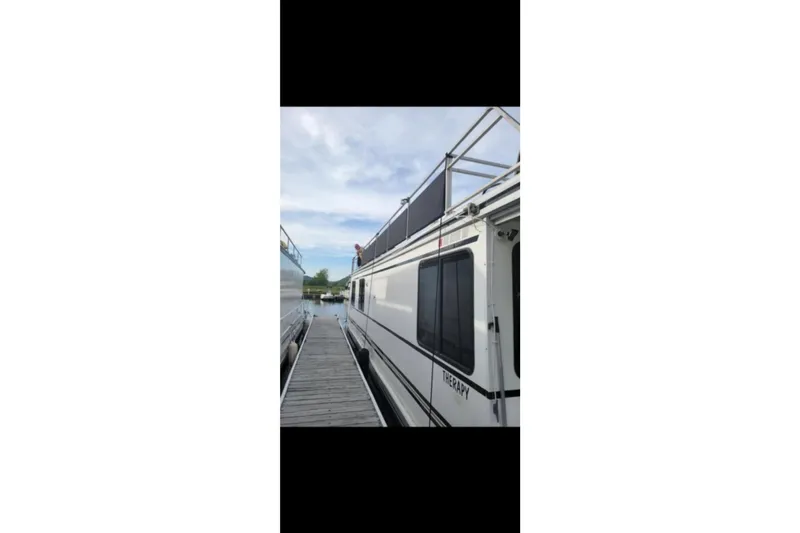 Slide: The Image of 2000 Catamaran Cruisers 48 docked, side view with clear sky background. - 7