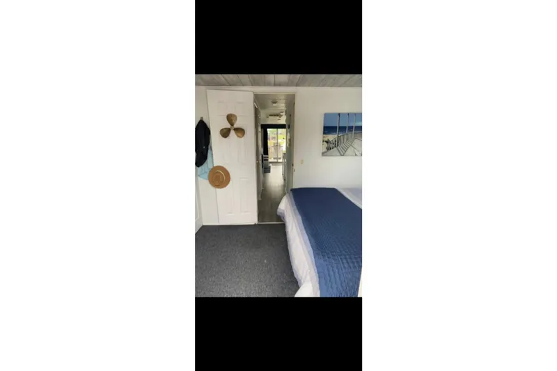 Slide: The Image of Interior of 2000 Catamaran Cruisers 48, featuring a cozy bedroom with nautical decor. - 8