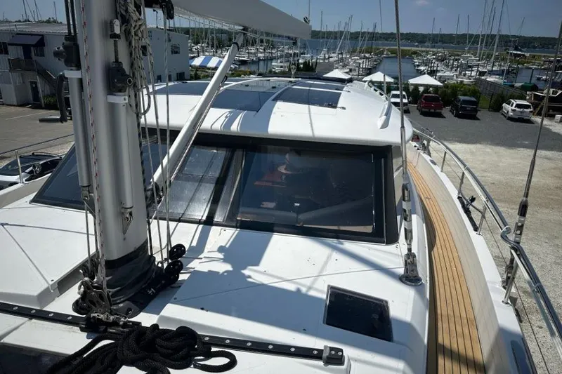 Slide: The Image of 2019 Moody 54 DS yacht docked at marina, showcasing deck and mast details. - 13