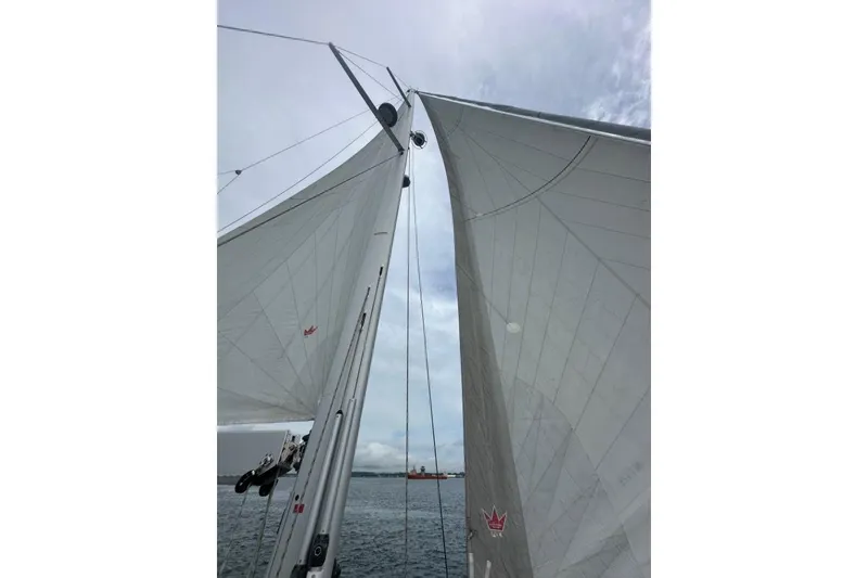Slide: The Image of Sails of a 2019 Moody 54 DS yacht against a cloudy sky. - 25