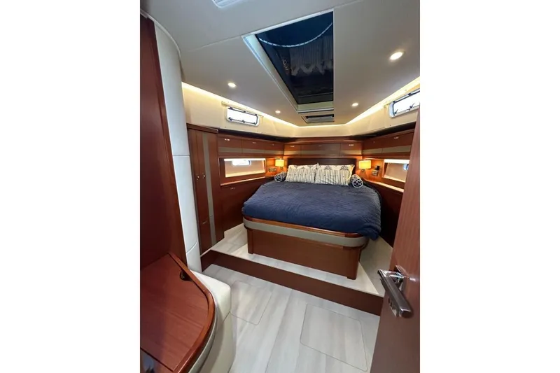 Slide: The Image of Luxurious 2019 Moody 54 DS yacht cabin with elegant wood finishes and cozy bedding. - 27