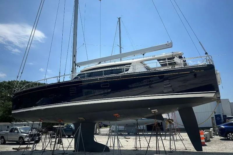 Slide: The Image of 2019 Moody 54 DS yacht on stands in a boatyard under clear blue sky. - 3