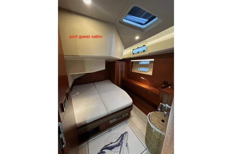Slide: The Image of Port guest cabin in 2019 Moody 54 DS yacht, featuring cozy bed and natural lighting. - 35
