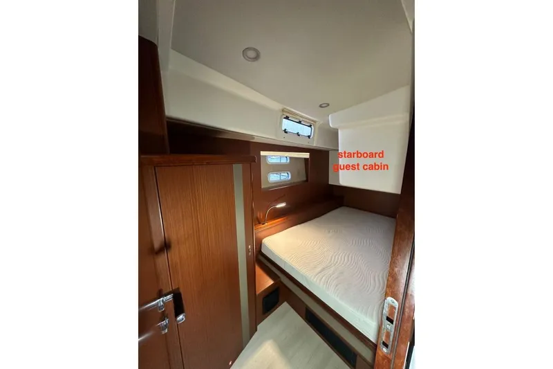 Slide: The Image of Starboard guest cabin in 2019 Moody 54 DS yacht, featuring wooden interior and cozy bed. - 36