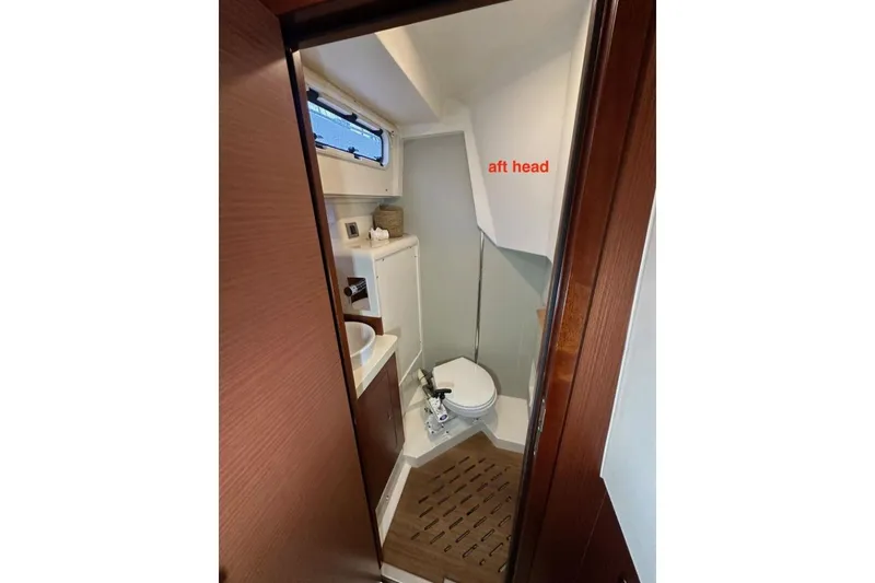 Slide: The Image of Aft head of 2019 Moody 54 DS yacht with compact design and wooden accents. - 48