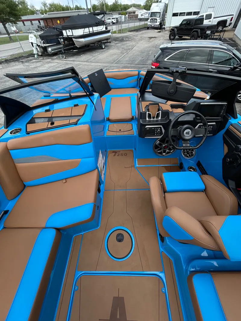 Slide: The Image of Interior of a 2023 Axis T250 boat with blue and brown seating. - 16