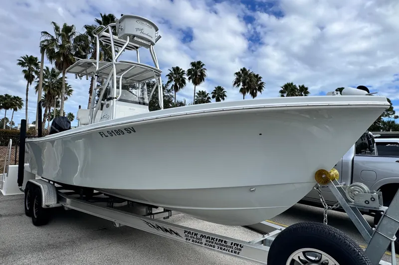 Slide: The Image of 2021 Pair Customs 24 Center Console MV boat on trailer, palm trees in background. - 2