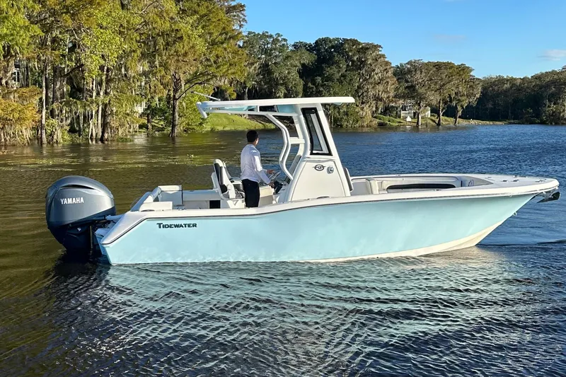 The Image of 2023 Tidewater 232 LXF boat on a serene lake with Yamaha engine. - 0