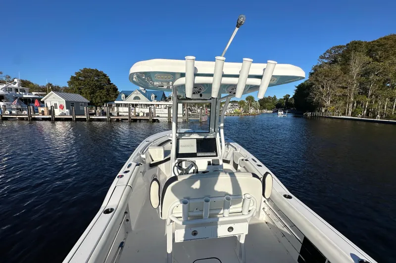 Slide: The Image of 2023 Tidewater 232 LXF boat on calm water near docks and trees. - 12
