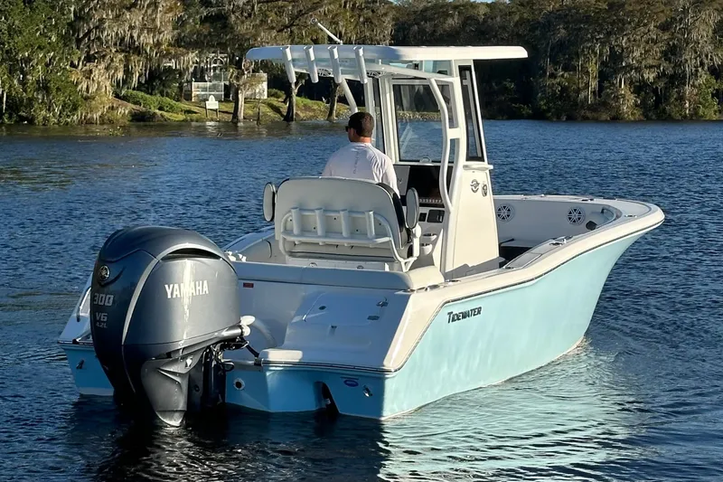 Slide: The Image of 2023 Tidewater 232 LXF boat with Yamaha engine cruising on a serene lake. - 2