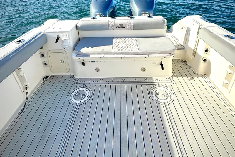 Slide: The Image of 2003 Pursuit 2870 Walkaround boat deck with seating and twin Yamaha 250 engines. - 11