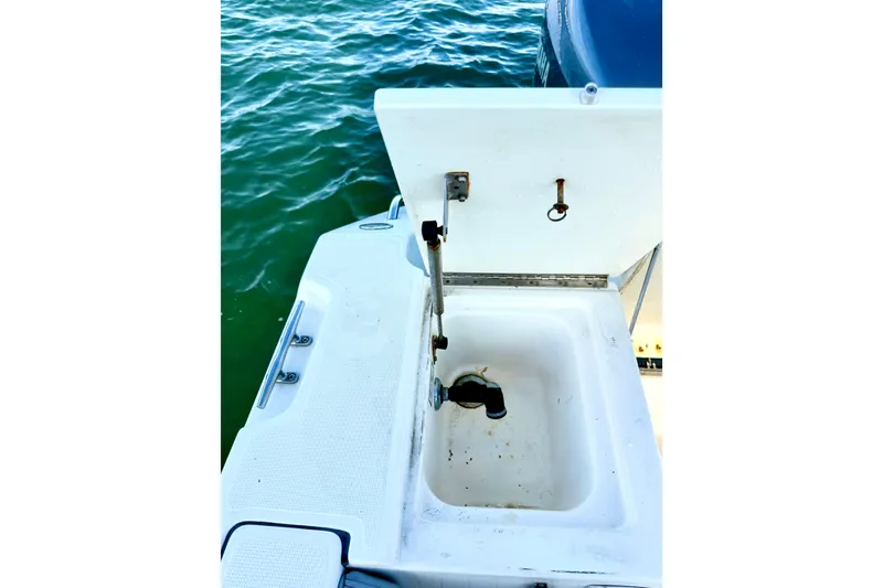 Slide: The Image of Open storage compartment on 2003 Pursuit 2870 Walkaround boat, near water. - 12