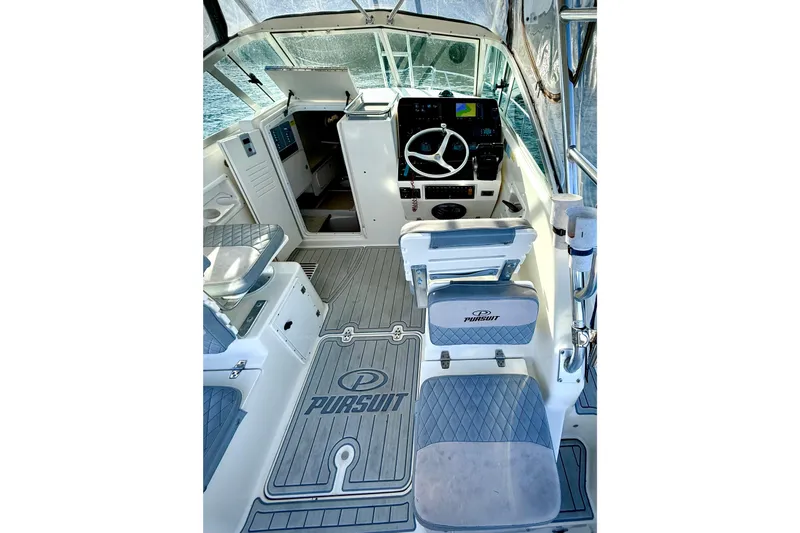 Slide: The Image of 2003 Pursuit 2870 Walkaround boat interior with helm, seating, and dashboard. - 14