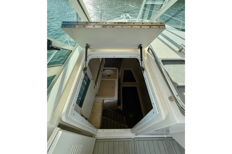 Slide: The Image of 2003 Pursuit 2870 Walkaround boat cabin entrance with open hatch, overlooking water. - 16